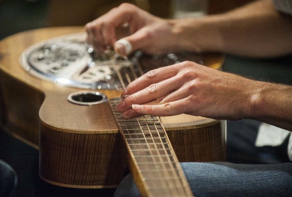 Mike Witcher practices and fine tunes his guitar before performing Thursday at the Chuck Jones Center for Creativity in Costa Mesa Thursday June 27 2013.  /// ADDITIONAL INFORMATION: 6/27/13 - cu.chuckjonesbenefit.0701 - STUART PALLEY, ORANGE COUNTY REGISTER -  Folk music artists perform at the Chuck Jones Center for Creativity on Thursday June 27, 2013 in Costa Mesa.